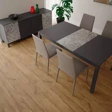 Sala de jantar com mesa escura e cadeiras claras sobre piso amadeirado.